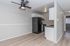 Modern apartment kitchen with sleek black appliances, bright cabinetry, and stylish wood flooring.