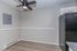 Chic kitchen area featuring modern ceiling fan, sleek black refrigerator, light wood flooring, and minimalist design accents.