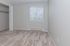 Bright bedroom with plush carpet, spacious closet, and large window with blinds, ideal for a cozy living space.