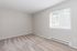 Bright and airy empty room with plush carpet and a large window inviting natural light.