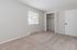 Bright and spacious bedroom with plush carpet, large window for natural light, and a convenient built-in closet.