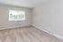 Bright, modern room featuring plush carpeting, large window with scenic view, and sleek baseboard heating.