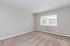 Bright and spacious room with fresh carpet, large window, and air conditioning unit, perfect for a cozy retreat.