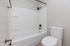 Modern bathroom featuring a sleek white bathtub and attractive fixtures, offering a clean and inviting space.