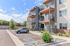 Modern apartment building with spacious balconies, landscaped surroundings, and convenient parking.