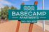 Inviting sign for Basecamp Apartments against a bright, sunny backdrop, promising a welcoming community.