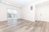 Bright and spacious living room with elegant wood flooring, large sliding glass doors, and abundant natural light.