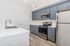 Modern kitchen with sleek stainless steel appliances, stylish gray cabinetry, and elegant white countertops.