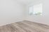 Bright and airy room with modern wood flooring and large window offering a refreshing outdoor view.