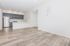 Modern open-concept living space with sleek hardwood floors, a stylish kitchen featuring stainless steel appliances, and elegant cabinetry.