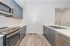 Modern kitchen with sleek grey cabinetry, stainless steel appliances, and elegant hardwood floors.