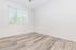 Bright, airy room with sleek hardwood flooring and large window with blinds, perfect for a cozy retreat.