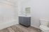 Modern bathroom with sleek vanity, elegant mirror, and pristine bathtub exudes contemporary charm.