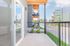 Bright and inviting balcony space with modern railings, offering a relaxing outdoor view of the vibrant surrounding neighborhood.
