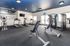 Modern apartment gym featuring state-of-the-art equipment, bright lighting, and sleek interior design.