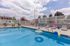 Inviting outdoor pool oasis with vibrant loungers, playful pool toys, and sunny skylines, perfect for relaxation and fun.
