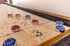 Close-up of a stylish shuffleboard table with red and blue pucks, perfect for entertainment and leisure in a modern apartment.
