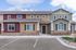 Charming townhouse exterior with inviting neutral tones, decorative shutters, and manicured landscaping, perfect for modern living.