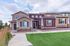 Charming townhouse exterior with a modern facade, stone accents, and inviting porch in a serene suburban setting.