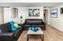 Cozy living room with elegant dark leather sofas, vibrant decor, and world map artwork, showcasing a stylish, inviting atmosphere.