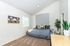 Inviting bedroom with stylish decor, featuring a cozy bed, contemporary artwork, lush plants, and ample natural light.