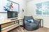 Modern home office with cozy bean bag chair, sleek computer desk, and large window offering abundant natural light.
