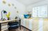 Bright and cozy bedroom featuring a stylish workspace with modern decor, vibrant yellow and blue bedding, and decorative star wall accents.