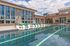 Luxurious modern apartment complex featuring a stunning outdoor pool with stylish seating and sleek architecture.
