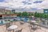 Chic rooftop patio with modern seating and panoramic views, perfect for relaxation and entertaining in a vibrant apartment community.