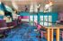 Vibrant lounge space featuring modern decor, plush seating, and a stylish bar with colorful accents.