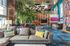 Vibrant and modern lounge area with colorful accents, featuring plush seating, tropical plants, and a sleek entertainment space.
