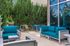 Modern outdoor patio adorned with vibrant teal seating, surrounded by lush greenery, ideal for relaxation and entertaining.