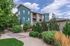 Charming apartment building surrounded by lush greenery and clear blue skies, perfect for tranquil living.