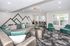 Contemporary living room with modern decor, featuring a plush gray sectional, vibrant green pillows, sleek geometric wall art, and ample natural light.