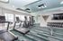 Modern fitness center featuring state-of-the-art treadmills, ellipticals, and a full set of dumbbells in a bright, spacious room.