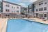 Inviting apartment complex with a modern pool area, surrounded by comfortable lounge chairs for a relaxing outdoor experience.