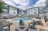Charming apartment complex featuring a pristine pool area with comfortable lounge chairs and a vibrant outdoor setting.