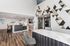 Modern apartment lobby with sleek marble countertops, geometric wall art, and warm wooden flooring, creating a welcoming and stylish atmosphere.