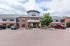 Charming brick apartment complex with a welcoming entrance adorned with balloons, ample parking space, and modern architecture.