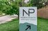 Inviting North Pointe Apartment Homes sign surrounded by lush green trees, showcasing welcoming entrance.