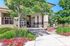 Inviting apartment entrance surrounded by lush greenery and vibrant flowers, highlighting a welcoming and serene atmosphere.