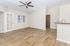 Bright and inviting living space with elegant wood flooring, modern ceiling fan, and open plan layout.