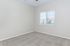 Bright and cozy room with soft carpet flooring, large window with blinds, and neutral color palette, perfect for bedroom or office space.