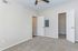 Bright, spacious bedroom with plush carpeting, neutral walls, and a ceiling fan, leading to a walk-in closet.