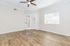 Elegant room with pristine hardwood floors, large window for natural light, and stylish ceiling fan, perfect for relaxing or hosting.