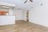 Chic open-floor living area with sleek hardwood flooring, modern kitchen, and inviting natural light.