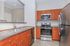 Modern kitchen with elegant wood cabinetry, stainless steel appliances, and sleek countertops, perfect for culinary enthusiasts.