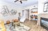 Chic living room with modern art, cozy fireplace, and stylish work nook, adorned with elegant furniture and warm accents.