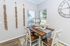 Charming dining nook with rustic wooden table, chic decor, and large windows offering natural light.