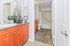 Elegant bathroom featuring modern fixtures, chic decor, and a spacious vanity with rich wood cabinetry.